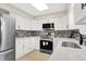 Well-lit kitchen with white cabinets, stainless steel appliances, quartz countertops, and decorative tile backsplash at 5015 Nowland Ave, Indianapolis, IN 46201
