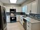 Modern kitchen with stainless steel appliances, white cabinets, stylish backsplash, and bright lighting at 5015 Nowland Ave, Indianapolis, IN 46201