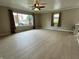 Bright living room features new laminate flooring, ceiling fan, neutral paint, and large windows allowing for plenty of natural light at 5015 Nowland Ave, Indianapolis, IN 46201