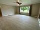 Spacious living room has laminate floors, neutral paint, ceiling fan, and bright windows at 5015 Nowland Ave, Indianapolis, IN 46201