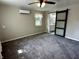 Carpeted main bedroom featuring a ceiling fan, and a modern sliding barn door leading to the ensuite bathroom at 5015 Nowland Ave, Indianapolis, IN 46201