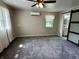 Carpeted main bedroom featuring a ceiling fan, and a modern sliding barn door leading to the ensuite bathroom at 5015 Nowland Ave, Indianapolis, IN 46201