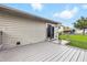 A well-maintained gray back deck with a sliding door, complemented by potted plants and a spacious grassy yard at 5305 Traditions Rd, Indianapolis, IN 46235