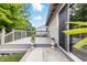 A beautiful gray stained back deck with railings, a sliding glass door, and elegant potted plants at 5305 Traditions Rd, Indianapolis, IN 46235