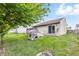 Expansive fenced backyard featuring a well-kept lawn, gray back deck, and mature trees offering shade at 5305 Traditions Rd, Indianapolis, IN 46235
