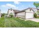 Charming home featuring a manicured lawn, flower beds, and a two-car attached garage at 5305 Traditions Rd, Indianapolis, IN 46235