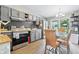 Modern kitchen with updated appliances, gray cabinets, tile backsplash and open dining area at 5305 Traditions Rd, Indianapolis, IN 46235