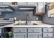 Close up of sink and stainless steel oven in modern kitchen with gray cabinets and black backsplash at 5305 Traditions Rd, Indianapolis, IN 46235