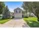 Charming two-story home with a driveway, front lawn, mature trees, and neutral-colored siding at 5519 Apple Branch Way, Indianapolis, IN 46237
