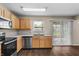 Well-equipped kitchen with stainless steel appliances, warm wood cabinets, and a view of the backyard at 5519 Apple Branch Way, Indianapolis, IN 46237