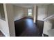 Inviting living room with dark floors, neutral walls, white trim, and natural light shining through the window at 5519 Apple Branch Way, Indianapolis, IN 46237