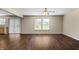 Spacious living room featuring dark wood-look floors, neutral paint, and natural light from the window at 5519 Apple Branch Way, Indianapolis, IN 46237