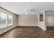 Bright living room featuring dark wood-look floors, a ceiling fan, and windows bringing in natural light at 5519 Apple Branch Way, Indianapolis, IN 46237