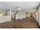 Open-concept living space with dark wood-look floors, a staircase, and a view into the kitchen with stainless appliances at 5519 Apple Branch Way, Indianapolis, IN 46237