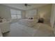 A well-lit bedroom has plush bedding, neutral décor, a ceiling fan, and a sunlit window at 5527 Mahogany Dr, Noblesville, IN 46062