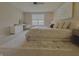 A cozy bedroom features plush bedding, a ceiling fan, a window view, and a makeup vanity at 5527 Mahogany Dr, Noblesville, IN 46062