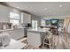 Open kitchen and living room area with white island, stainless appliances and hardwood floors at 5527 Mahogany Dr, Noblesville, IN 46062