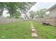 Large backyard with a grassy lawn and stepping stones leading into the space at 555 N Oakland Ave, Indianapolis, IN 46201