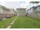 A spacious backyard with a grassy lawn and a quaint stepping stone pathway leads to the rear of the home at 555 N Oakland Ave, Indianapolis, IN 46201