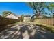 View of a long gravel driveway and fenced backyard with a neighboring home at 555 N Oakland Ave, Indianapolis, IN 46201