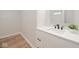 Bathroom vanity with white cabinets, countertop, black hardware and faucet, with a modern mirror at 555 N Oakland Ave, Indianapolis, IN 46201