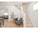 Bright foyer featuring hardwood floors, stairs, and an inviting chair at 555 N Oakland Ave, Indianapolis, IN 46201
