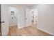 Bright hallway with wood floors, white trim, and access to a bedroom and the laundry room at 555 N Oakland Ave, Indianapolis, IN 46201