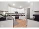 Chic kitchen equipped with stainless steel appliances, white cabinets, and wood-style flooring at 555 N Oakland Ave, Indianapolis, IN 46201
