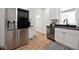 Charming kitchen featuring stainless steel appliances, white cabinets, and hardwood floors at 555 N Oakland Ave, Indianapolis, IN 46201