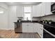 Well-lit kitchen boasting stainless steel appliances, dark countertops, and white cabinetry at 555 N Oakland Ave, Indianapolis, IN 46201