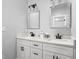 Elegant bathroom with white cabinetry, double sink vanity, modern lighting fixtures, and square mirrors at 5678 N College Ave, Indianapolis, IN 46220