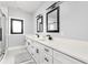 Well-lit bathroom features double sinks, long countertop, black fixtures, and subway tile in the shower at 5678 N College Ave, Indianapolis, IN 46220