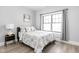 Bright bedroom features a large window, wood floor, and a cozy bed with floral pattern bedding at 5678 N College Ave, Indianapolis, IN 46220