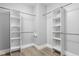 Walk-in closet featuring wood floor and custom shelving with rods for optimal storage solutions at 5678 N College Ave, Indianapolis, IN 46220
