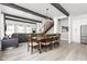 Bright, open-concept living and dining area with a modern staircase and sleek, dark wooden beam ceiling at 5678 N College Ave, Indianapolis, IN 46220