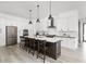 Spacious, modern kitchen with an island, white cabinets, stainless steel appliances, and stylish pendant lighting at 5678 N College Ave, Indianapolis, IN 46220