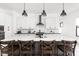 Modern kitchen features a large island with bar stool seating, white cabinets, and sleek pendant lighting at 5678 N College Ave, Indianapolis, IN 46220