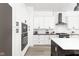 Contemporary kitchen boasts stainless appliances, white cabinets, a subway tile backsplash, and a contrasting dark island at 5678 N College Ave, Indianapolis, IN 46220