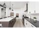 Open-concept kitchen with a large island, stainless steel appliances, white cabinets, and dark countertops at 5678 N College Ave, Indianapolis, IN 46220