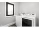 Laundry room features new washer and dryer, hex tile floor, and natural light from an exterior window at 5678 N College Ave, Indianapolis, IN 46220