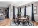 Elegant dining room with a round table, chandelier, and large windows with blue curtains at 5832 Buskirk Dr, Indianapolis, IN 46216