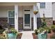 Close up view of home's entry way featuring flower pots, hanging planters and an inviting door at 5832 Buskirk Dr, Indianapolis, IN 46216