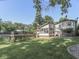 Backyard featuring a pool, spacious deck, enclosed patio, and a well-maintained lawn surrounded by mature trees at 6019 S Tacoma Ave, Indianapolis, IN 46227