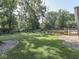 Expansive backyard with lush green lawn, mature trees, garden and spacious deck at 6019 S Tacoma Ave, Indianapolis, IN 46227