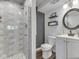 Modern bathroom featuring a sleek shower with gray subway tile and a stylish vanity with a round mirror at 6019 S Tacoma Ave, Indianapolis, IN 46227