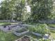 Lush garden with gravel paths, mature plants, raised beds, and wooden bridge at 6019 S Tacoma Ave, Indianapolis, IN 46227
