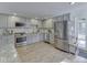 Well-lit kitchen features stainless steel appliances, gray cabinetry, and granite countertops at 6019 S Tacoma Ave, Indianapolis, IN 46227