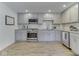 Well-lit kitchen featuring stainless steel appliances, gray cabinetry, and granite countertops at 6019 S Tacoma Ave, Indianapolis, IN 46227