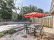 Relaxing patio area featuring a stone surface, outdoor dining set, and a vibrant red umbrella for shade in the backyard at 6019 S Tacoma Ave, Indianapolis, IN 46227