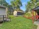 View of the home's backyard with green grass, detached garage, and shelter at 637 Olin Ave, Indianapolis, IN 46222